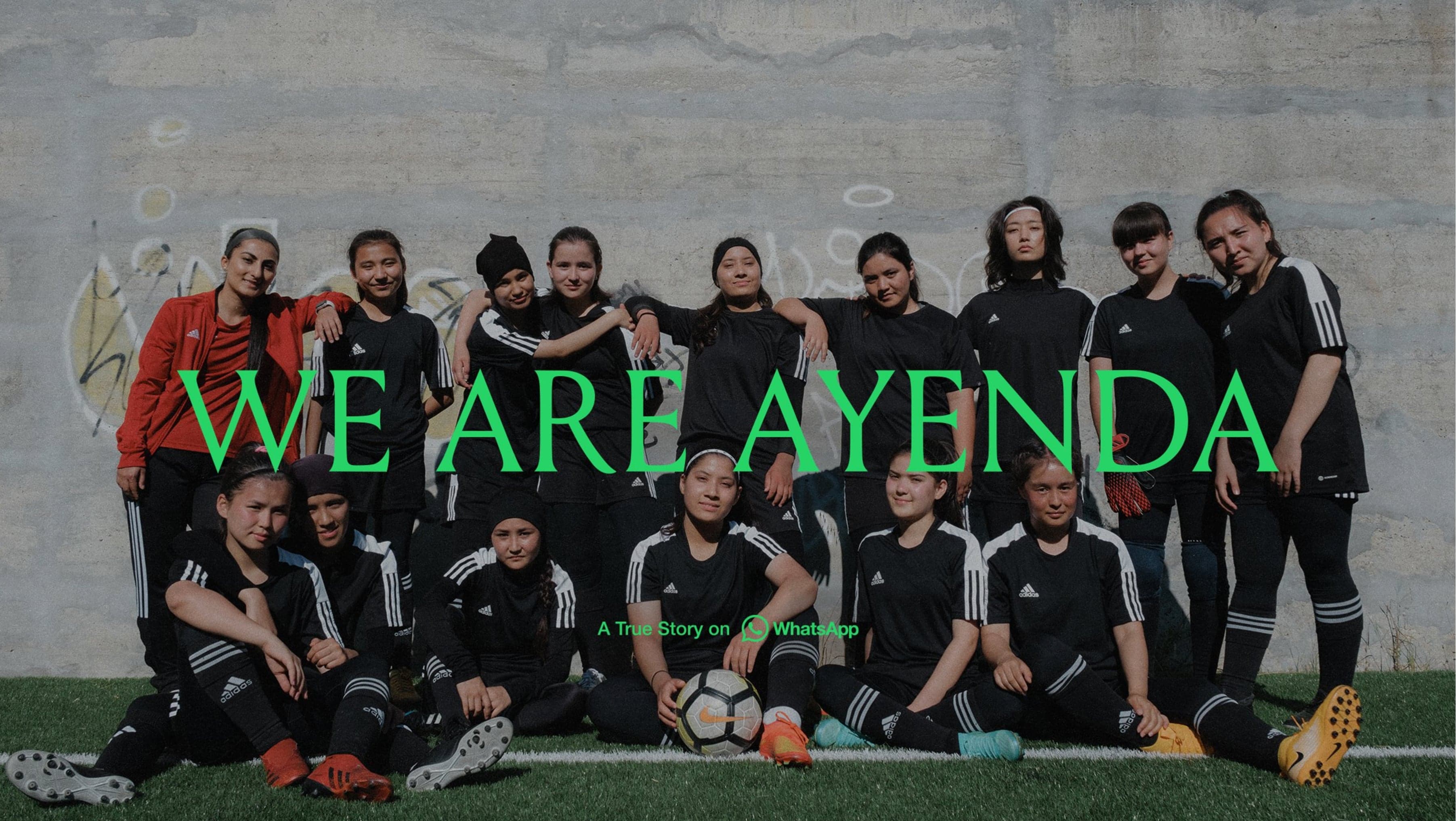 A women's soccer team in black uniforms poses on grass against a concrete wall. Text reads "We Are Ayenda. A True Story on WhatsApp" in green.