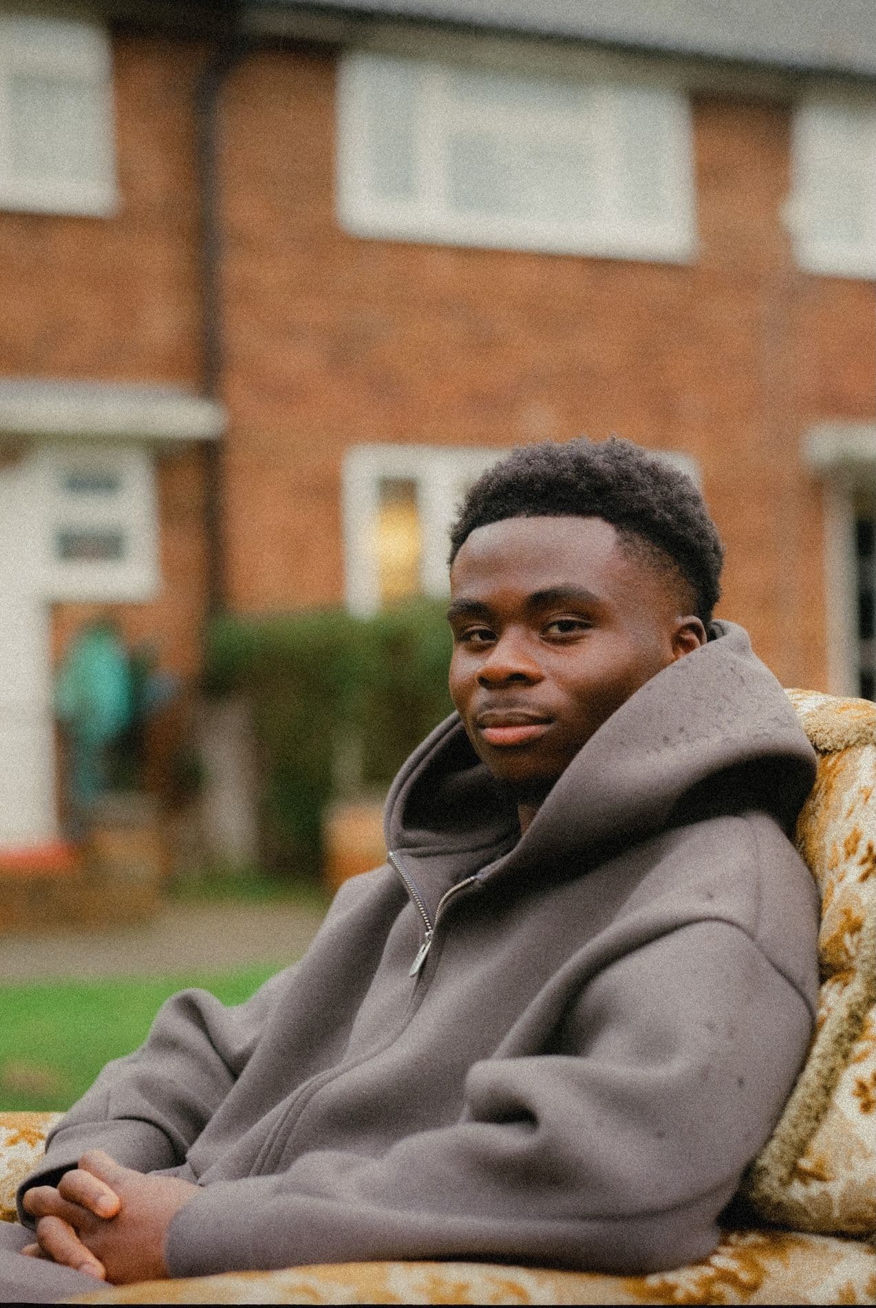 man sitting in chair outside looking at camera